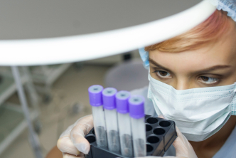 A scientist looks intently at the specimens in her lab. 